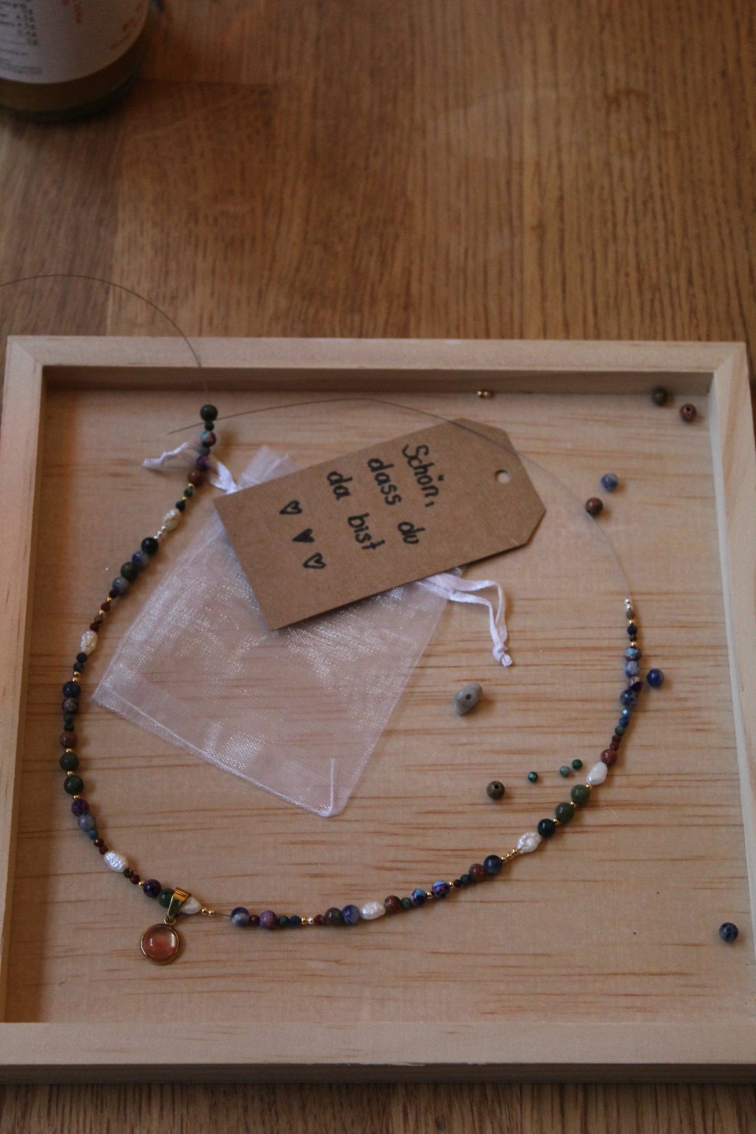 Fertige Kette mit Perlen im Holz-Tablett