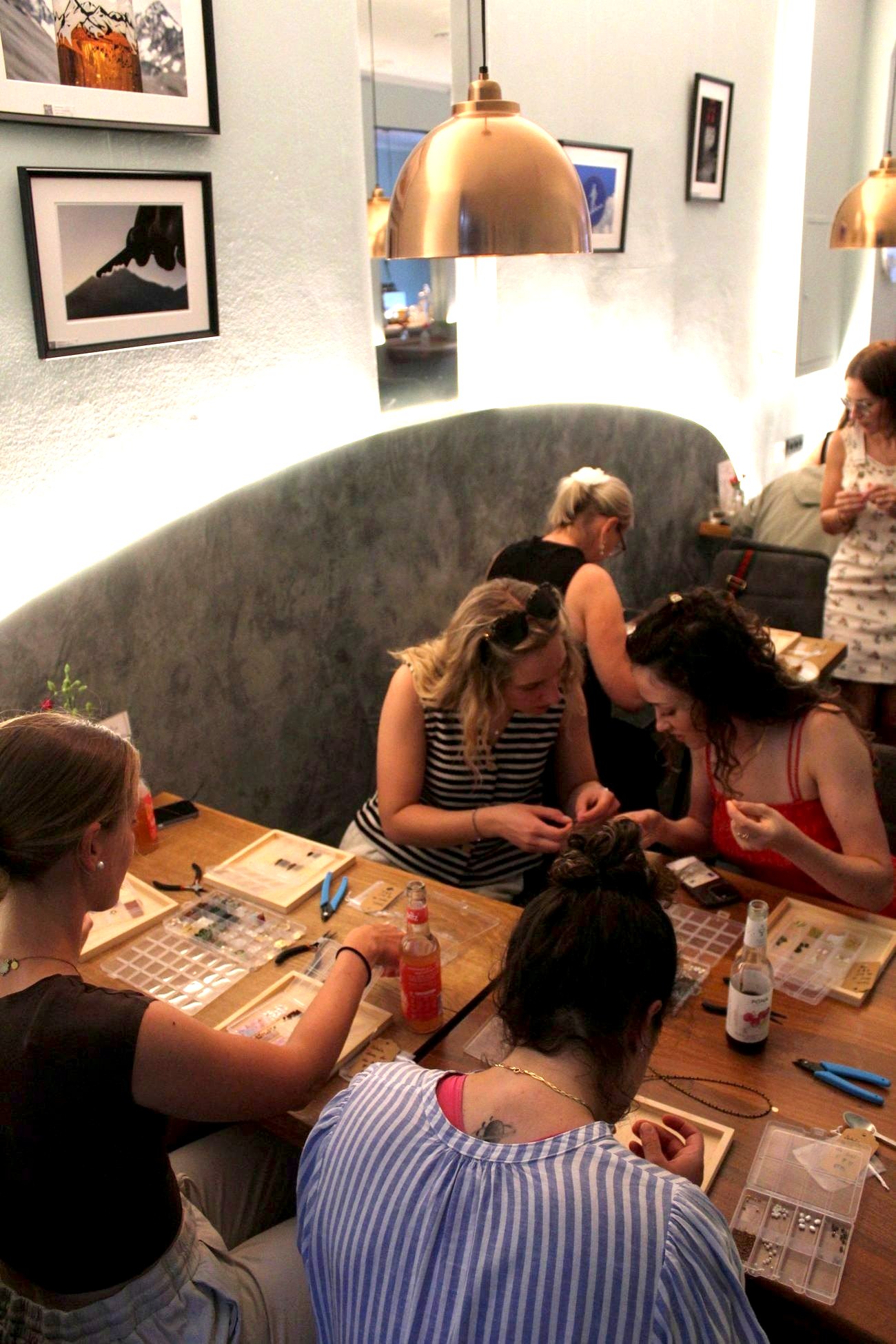 Frauen gestalten gemeinsam Schmuck im Café